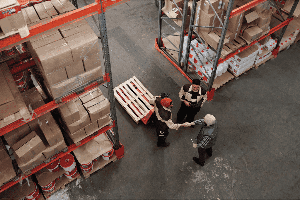 People shaking hands in a warehouse.