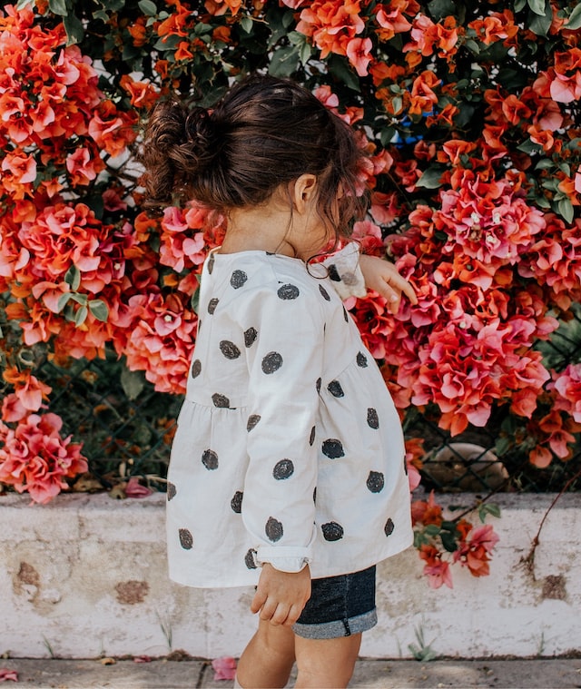 A young girl admiring flowers