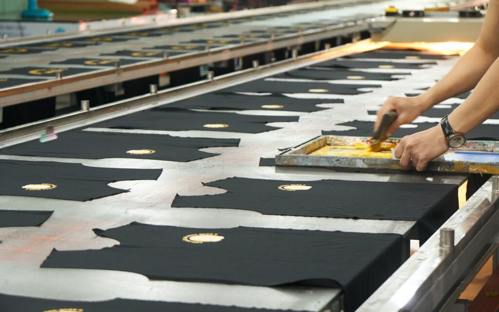 A row of garments being screen printed