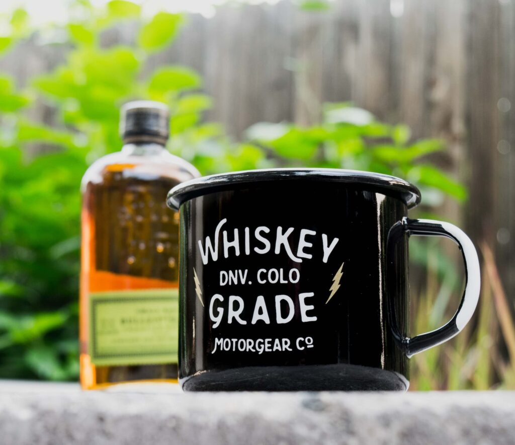 A mug with a bottle of whiskey in the background