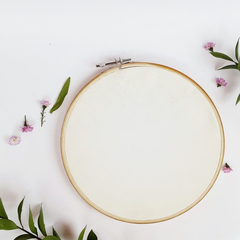 A round hoop sitting atop an embroidered fabric
