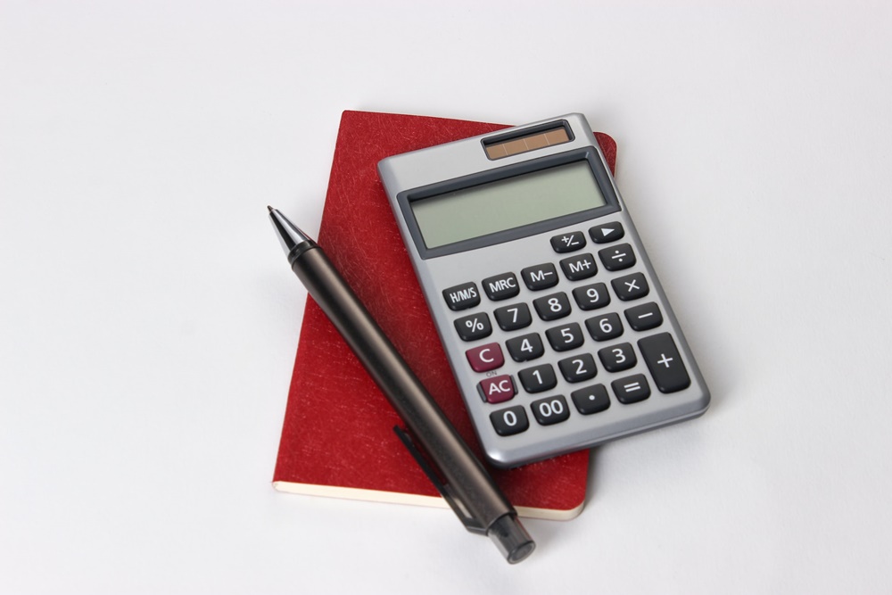 A pen, a small red book, and a calculator