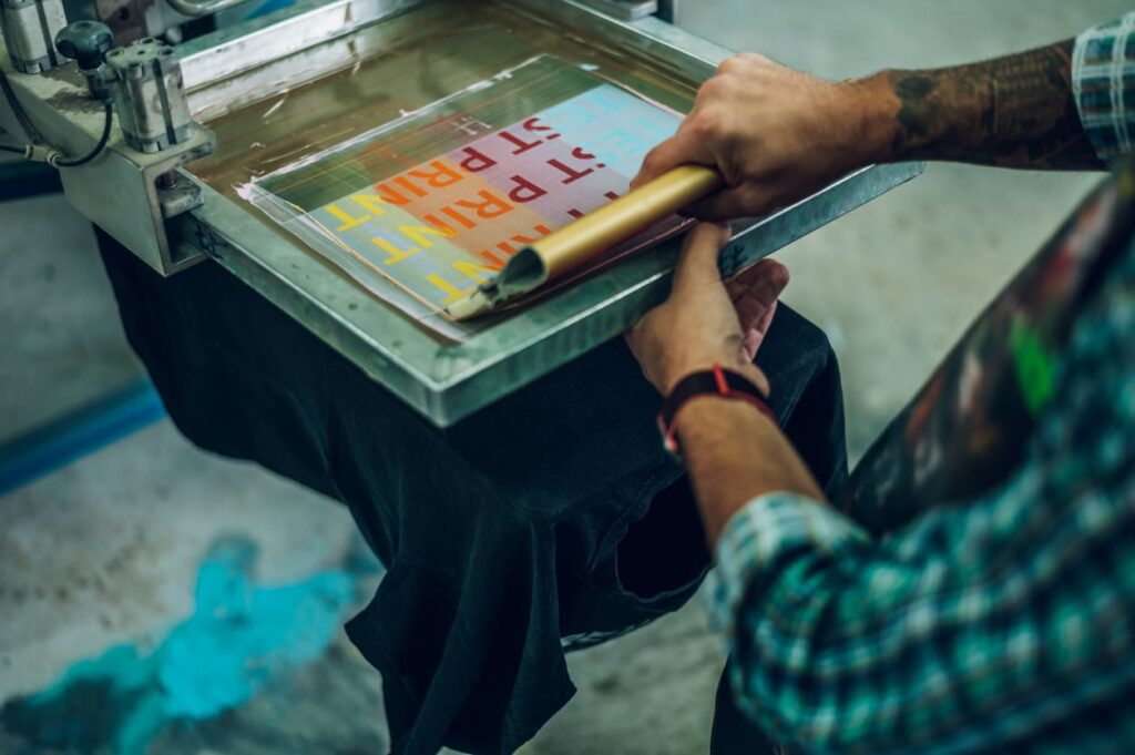 A man prepares to push his squeegee for a screen printing job