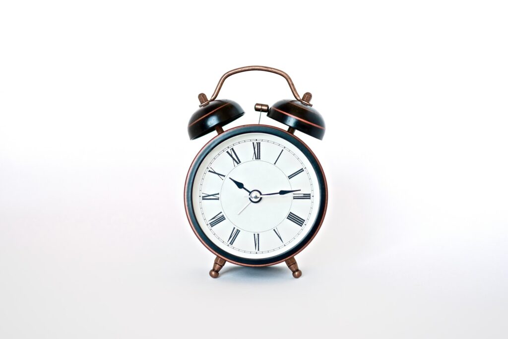 An analog alarm clock on a white background