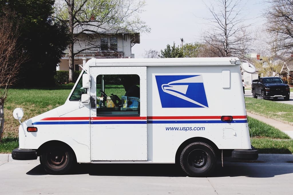 A USPS postal truck parked outside a residence